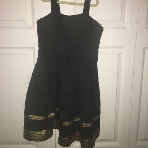 Elisa B. Dress in black with gold trimming